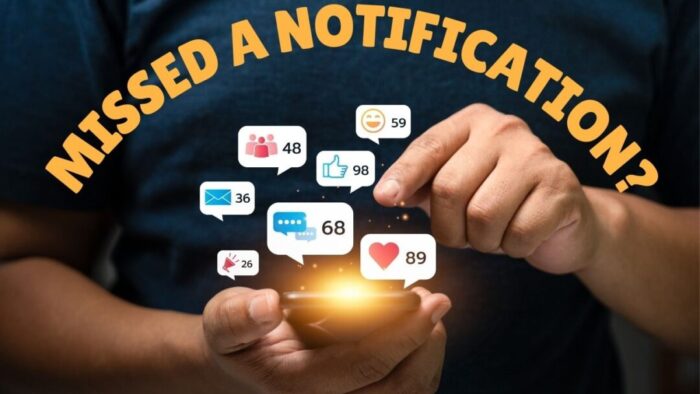 Chest and arms of person in a black t-shirt holding an iPhone that has a gold glow at the top. Just above the phone are overlaid images of seven different kinds of notification emojis. In yellow text rounded over the person's arms it reads Missed a notification?