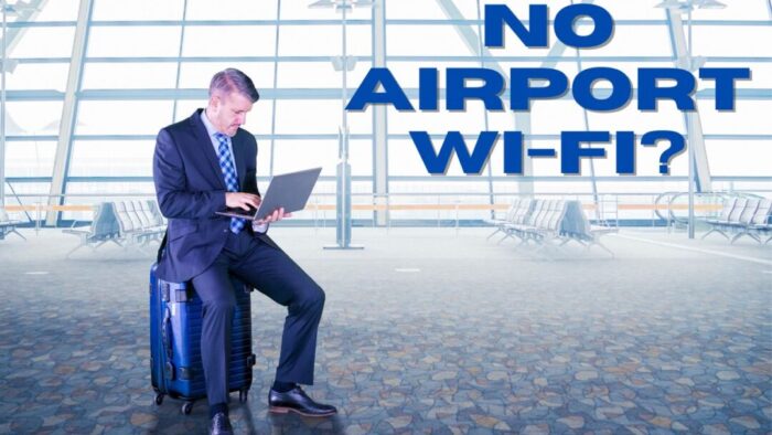 Man in a blue suit sitting on a blue hard-shell suitcase in an airport waiting area. Blue text reads No airport wi-fi?