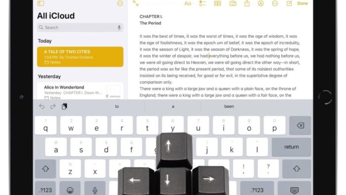 iPad screen in the Notes app with the keyboard visible. A set of four-directional arrow keys are laid on top of the iPad screen.