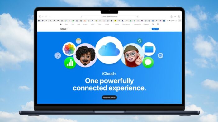 Mac laptop with Safari opened to Apple's iCloud website. Text reads "iCloud+ One powerfully connected experience. Background is a cloudy blue sky