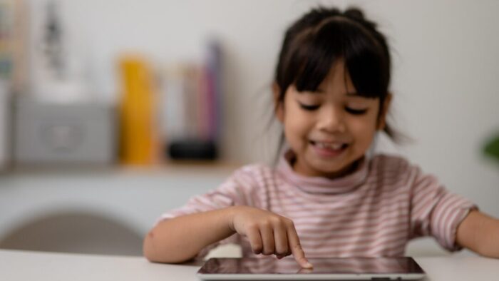 small child pointing her finger on an iPad.