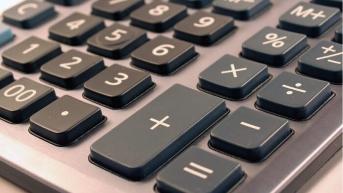 close up diagonal view of an old-school handheld calculator with raised buttons