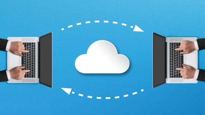two laptops on a blue background, one on each side of the image. a cloud sits between the laptops, as well as a top dashed arrow going from left to right and another dashed arrow going right to left, indicating a transfer of information between the two laptops.