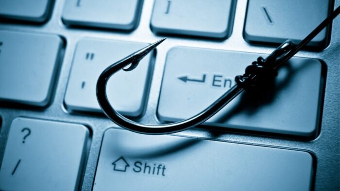 a fish hook laid over the enter key of a keyboard.