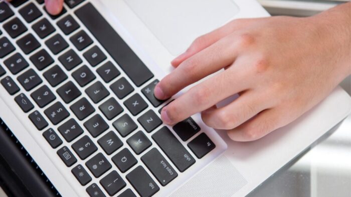 overhead view of a hand on a keyboard with fingers resting on the command and control keys