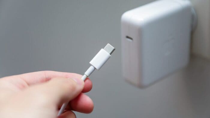 hand of a person plugging in a usb-c cable to a power brick that's already plugged into the wall.