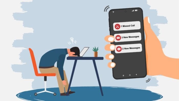 illustration of a disembodied right hand holding a phone in front of a person with their head down on their desk.