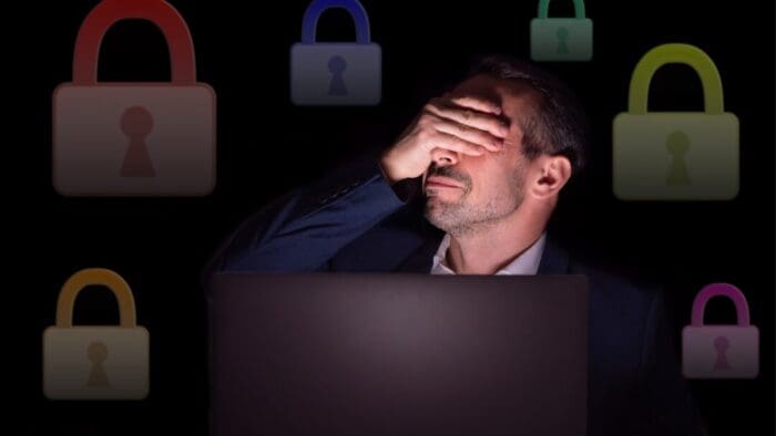 guy with his face lit by the light of his laptop, hand over face regretting his life choices.