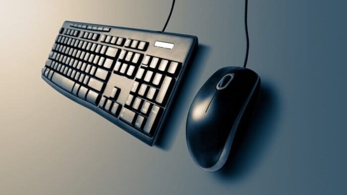a black keyboard and mouse against a dark gray surface